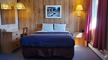 Escritorio, cortinas blackout y tabla de planchar con plancha