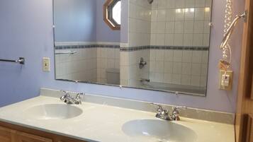 Une salle de bain avec deux lavabos, un miroir et un porte-serviettes.
