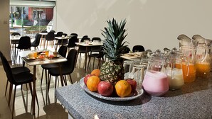 A breakfast setup with fruit, beverages, and a view of the street. - Riviera Hoteles Ejecutivo (Arequipa)