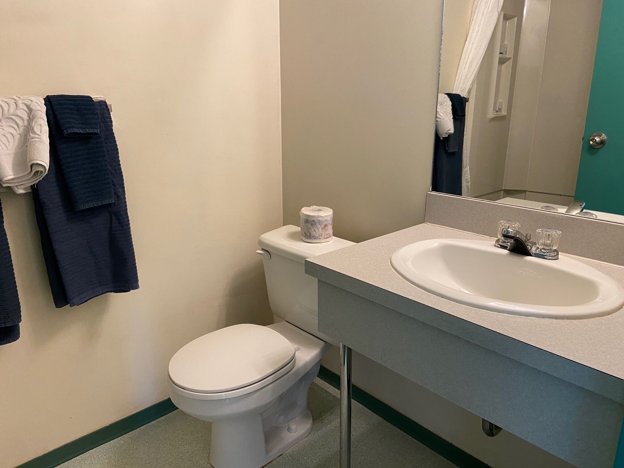 Un baño con inodoro, lavabo y espejo.
