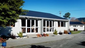 A single-story building with a flat roof, large windows, and a white exterior. - Apostles View Motel (Greymouth)