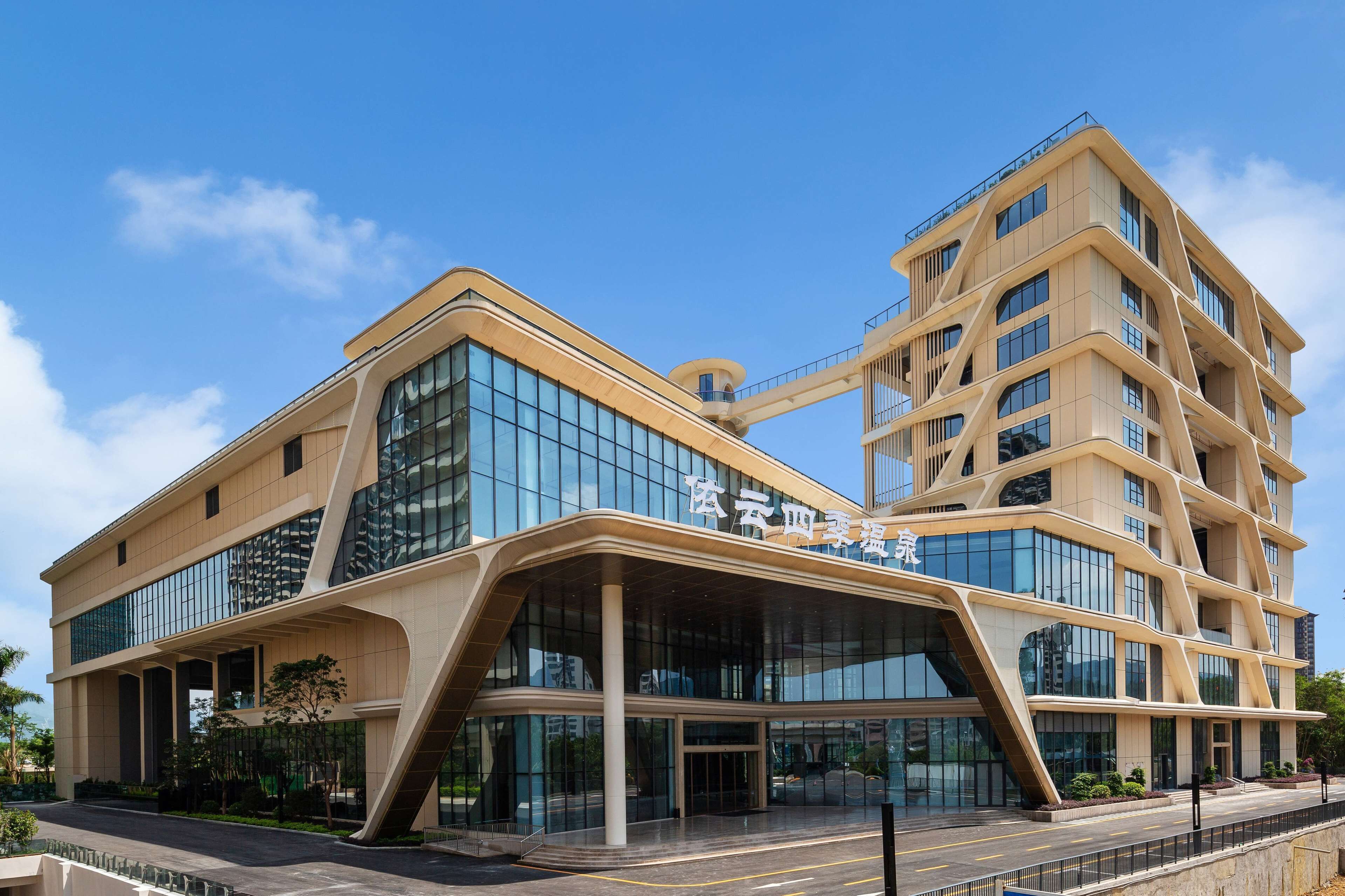 A modern building with a curved facade, large glass windows, and a prominent entrance.