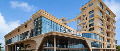 A modern building with a curved facade, large glass windows, and a prominent entrance.