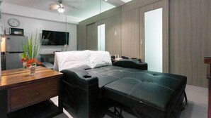 A modern bedroom with a bed, bedside table, and a TV. - Francisco Place (Pasay)