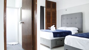 A hotel room with a large bed, a smaller bed, a wardrobe, and a door. - Hotel Pal Cozumel (Cozumel)