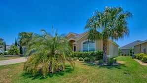 A residential area with houses, well-maintained lawns, and palm trees. - BEAUTIFUL HOME GAS GOLF CART NEAR BROWNWOOD PADDOCK SQ    THE VILLAGES FL (The Villages)
