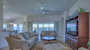 A spacious living room with a ceiling fan, a sofa set, a coffee table, and a TV stand. - BEAUTIFUL HOME GAS GOLF CART NEAR BROWNWOOD PADDOCK SQ    THE VILLAGES FL (The Villages)