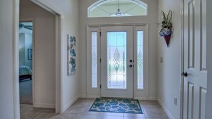 A hallway with a double door, a blue patterned rug, and a ceiling fan. - BEAUTIFUL HOME GAS GOLF CART NEAR BROWNWOOD PADDOCK SQ    THE VILLAGES FL (The Villages)