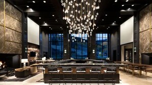 Un hall d’entrée spacieux avec un grand bar, des espaces aménagés pour s’asseoir et une cheminée.
