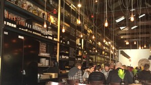 A restaurant interior with exposed brick walls, hanging light bulbs, and wooden tables and chairs. - New apartment in the historic West End close to cafes bars and restaurants.  (Fremantle)