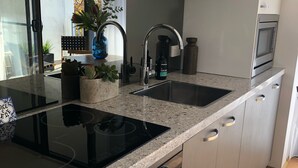 A modern kitchen with a double sink, stainless steel appliances, and a built-in oven. - New apartment in the historic West End close to cafes bars and restaurants.  (Fremantle)