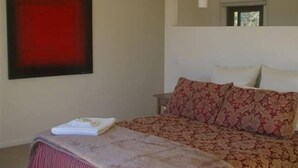 A bedroom with a bed, a bedside table, a red abstract painting, and a window. - Casina Marcella - country house (Basalt)