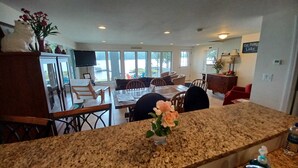 A spacious kitchen with granite countertops, a dining area with a large table, and a view of the outdoors through large windows. - Perfect Lakefront Getaway ~ Beautiful Private Setting!  (Dedham)