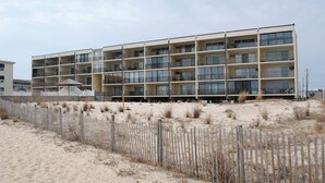 A multi-story hotel with a flat roof and balconies on each floor. - Traditional 1 Bedroom Oceanfront Condo with Free WiFi, an Outdoor Pool, and a Wonderful View Located in Midtown and Mere Steps to the Beach! (Ocean City)