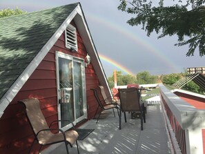 A red building with a glass door and a covered patio area with chairs and a table. - Loft at Red Rock ✦ Best COS Area❣ (Colorado Springs)