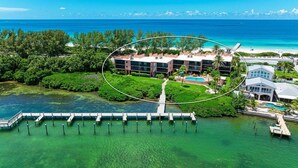 Una vista aerea di un resort con piscina, molo e spiaggia.