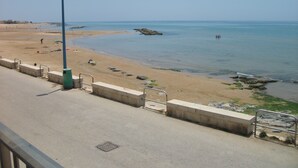 A beach with a concrete walkway, a trash bin, and a street lamp. - Apartment/ flat - Scicli (Donnalucata)