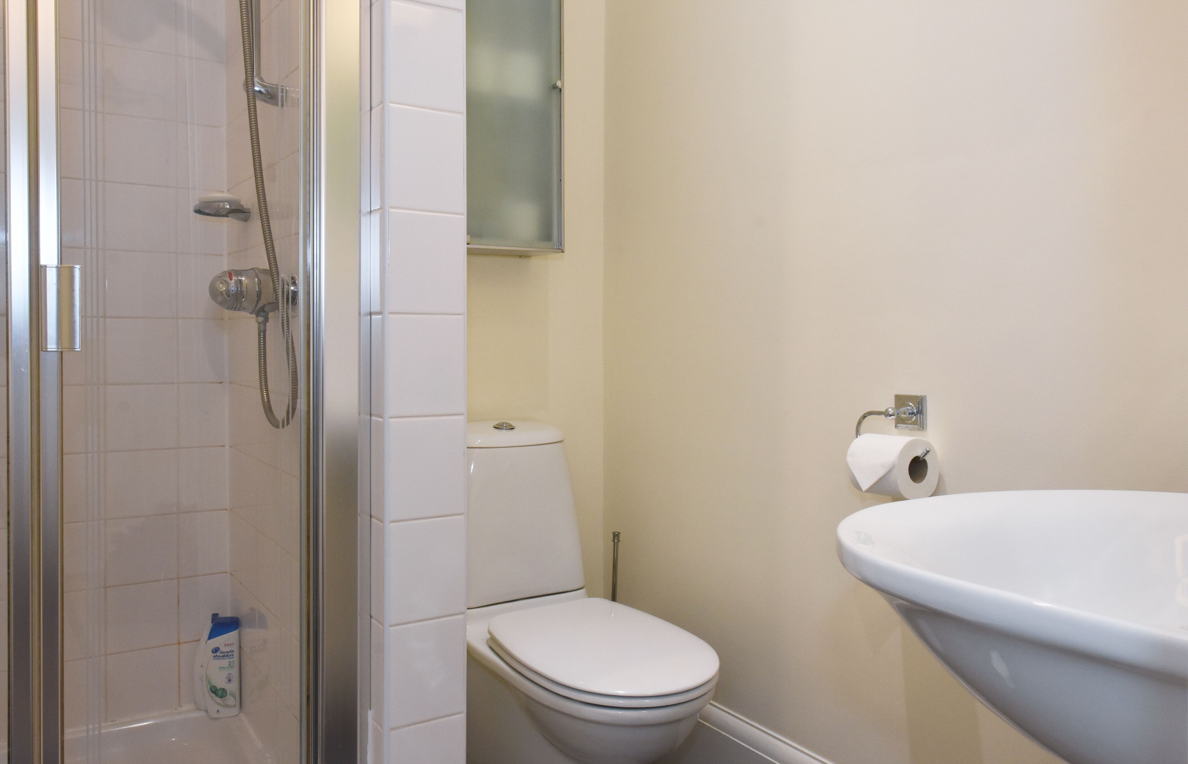 A bathroom with a shower, toilet, and sink.