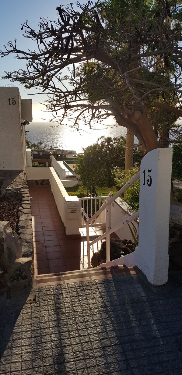 A staircase leading to a building with a view of the sea. - Refurbished 2-bed in popular Los Gigantes w/ private garden, terrace & sea views (Los Gigantes)