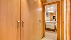 A hallway with wooden wardrobes and a bathroom with a sink and mirror. - Apt. with 4 pools, very close to Fenals beach, 6 pax, air conditioning and free wifi. (Lloret de Mar)