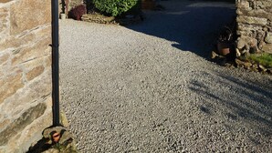 A stone building with a gravel driveway leading to a wooden structure. - Stunning uninterrupted moorland views over lake and Rough Tor (Advent)
