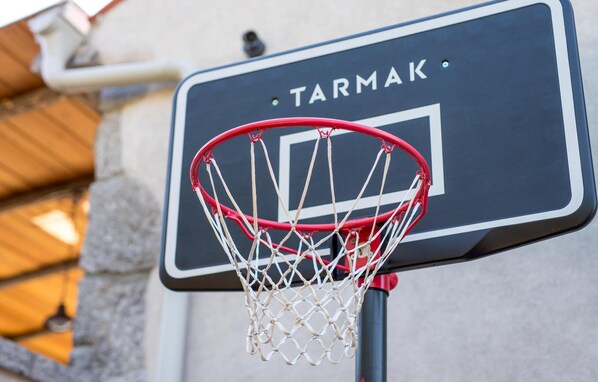 A basketball hoop with a sign that reads "TARMAK" attached to a wall.