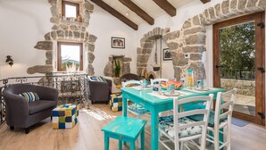 A cozy dining area with a stone wall, wooden beams, and a view of the outdoors. - Awesome home in Kornic (Kornic)