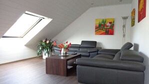 A modern living room with a sectional sofa, a coffee table, and a skylight. - Modern, exclusive and bright apartment in Rees (Rees)