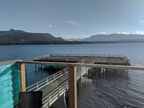 A pier extending into a lake with a mountainous backdrop.
