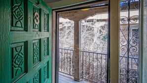 Una porta verde con elaborate decorazioni floreali e un balcone con ringhiere in metallo.