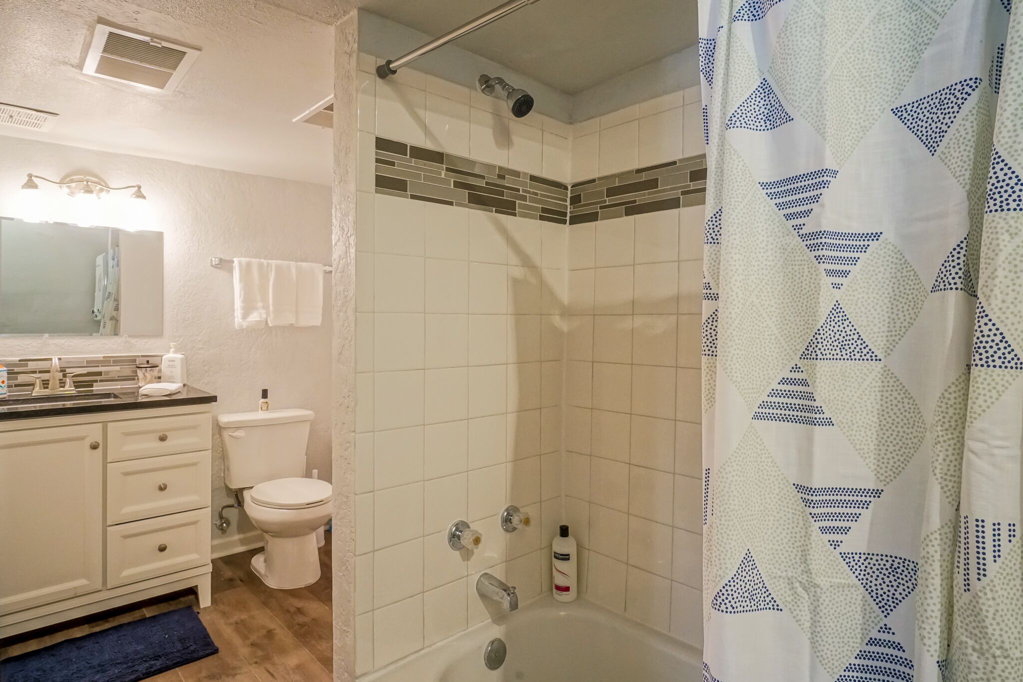 Un baño con ducha, inodoro y lavamanos.