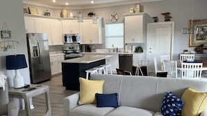 A modern kitchen with white cabinets, stainless steel appliances, and a central island. - Sea Shell Haven 
Family Home, 300 yards from the beach, 2 private docks, Grill! (Placida)
