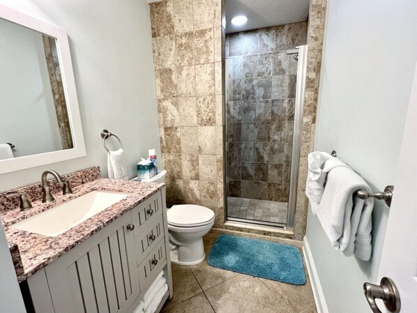 A bathroom with a sink, toilet, and shower. - Ocean Mist - Beauty and The Beach! - Pool Access (St. Augustine Beach)