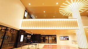 A modern hotel lobby with a glass entrance, a reception desk, and a spiral light fixture. - Hotel Abest Grande Okayama (Okayama)