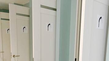 Una fila de puertas blancas con un símbolo de ducha, indicando instalaciones para duchas.