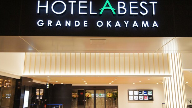 The exterior of HOTEL BEST GRANDE OKAYAMA with a modern facade, illuminated signage, and a clear entrance. - Hotel Abest Grande Okayama (Okayama)