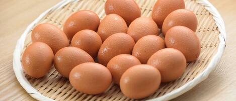 A basket of eggs on a woven mat.