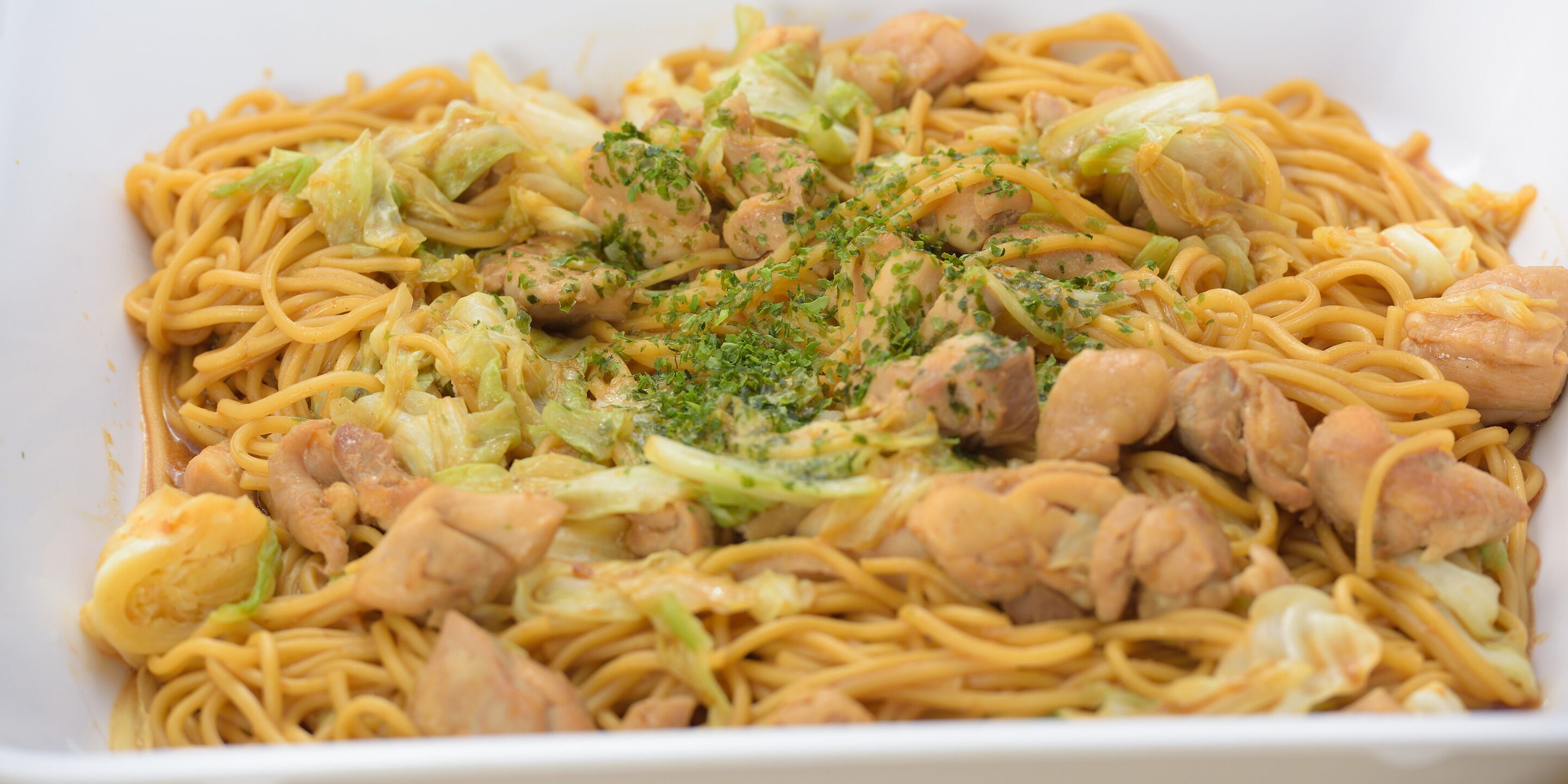 A dish of noodles with vegetables and meat.