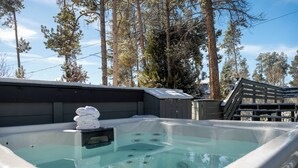 Een hottub met een houten terras en een stap handdoeken.