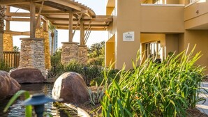 Un hôtel doté d’une façade en pierre, d’un espace extérieur couvert agrémenté d’un élément décoratif aquatique, et d’une enseigne indiquant le numéro de chambre 5000.