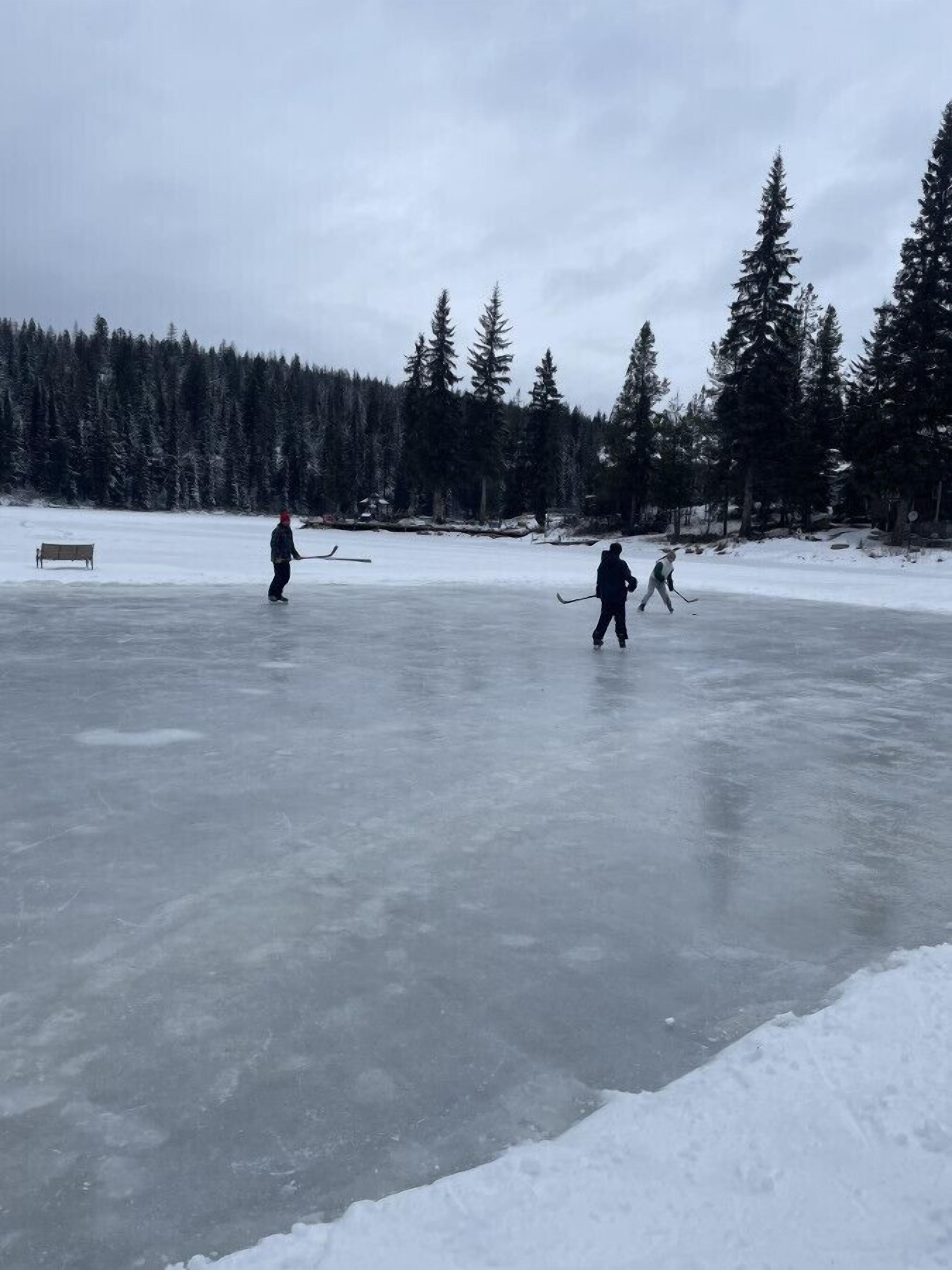 Jäätynyt järvi, jolla ihmiset luistelevat ja pelaavat jääkiekkoa.