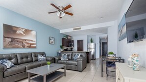 A modern living room with a grey sofa, a coffee table, and a ceiling fan.