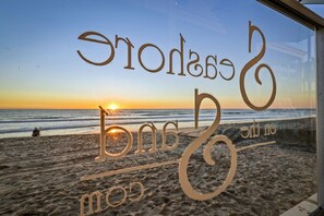 A beach view with a sunset and the words "Eros, bns, no love" etched on a glass window. - 1 Bedroom Condo on the Sand! (Carlsbad)