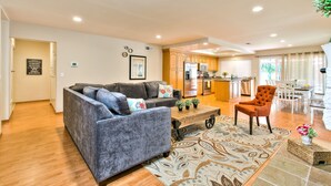 A modern living room with a grey sofa, a wooden coffee table, and a patterned rug.