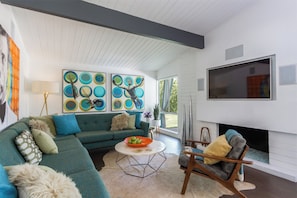 A modern living room with a sectional sofa, a round coffee table, and a fireplace.