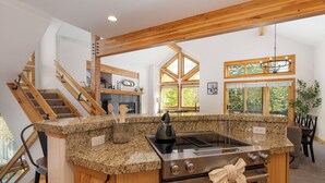 A kitchen with granite countertops, a built-in oven, and a wooden staircase. - Timber Lake 341 Private outdoor hot tub, views, garage parking (Winter Park)