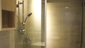 A modern bathroom with a glass-enclosed shower, a toilet, and a sink. - Ace Apartments Hong Kong (Kowloon)