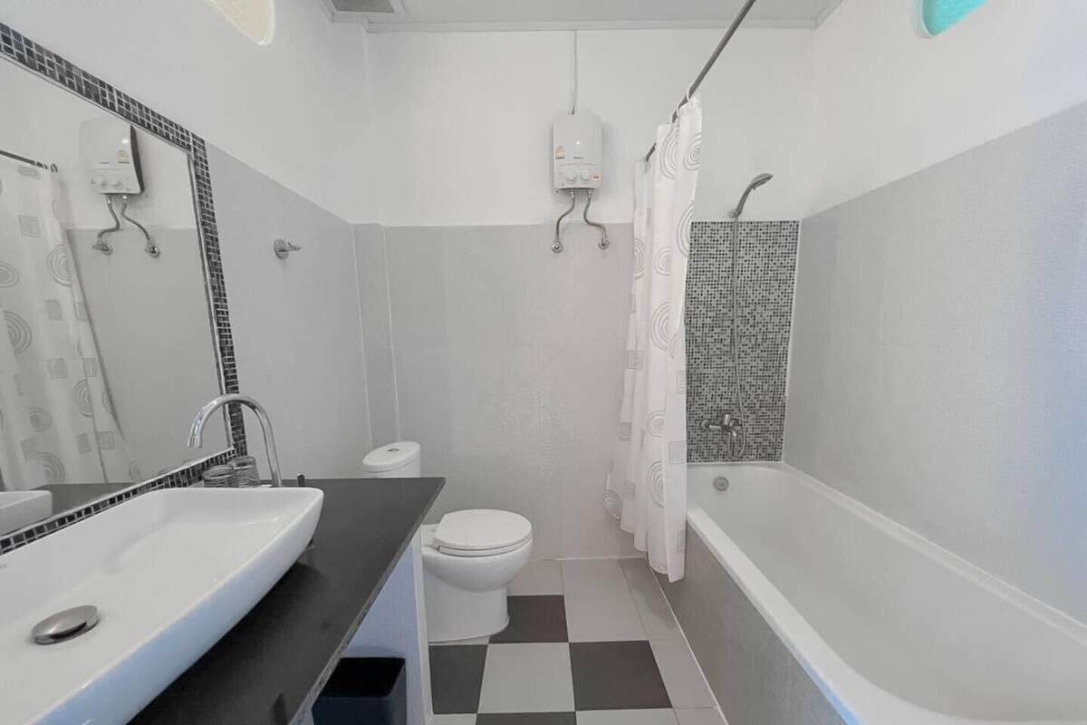 Un baño con bañera, inodoro y lavamanos.