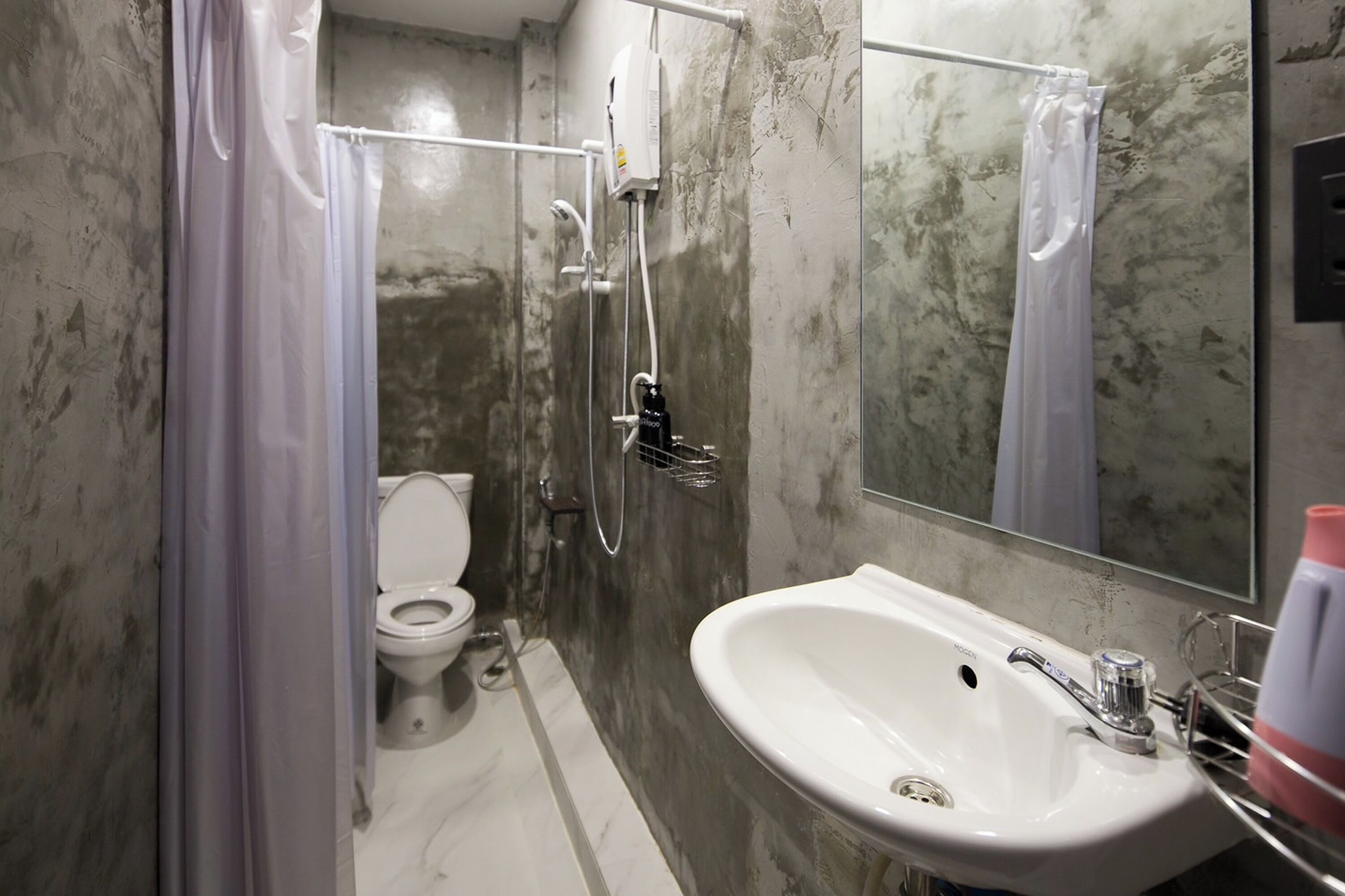 Un baño con inodoro, ducha y lavamanos.