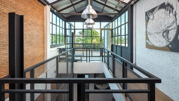 A modern interior with a glass ceiling, a mural, and a staircase. - Yindee Travellers Lodge (Nan)